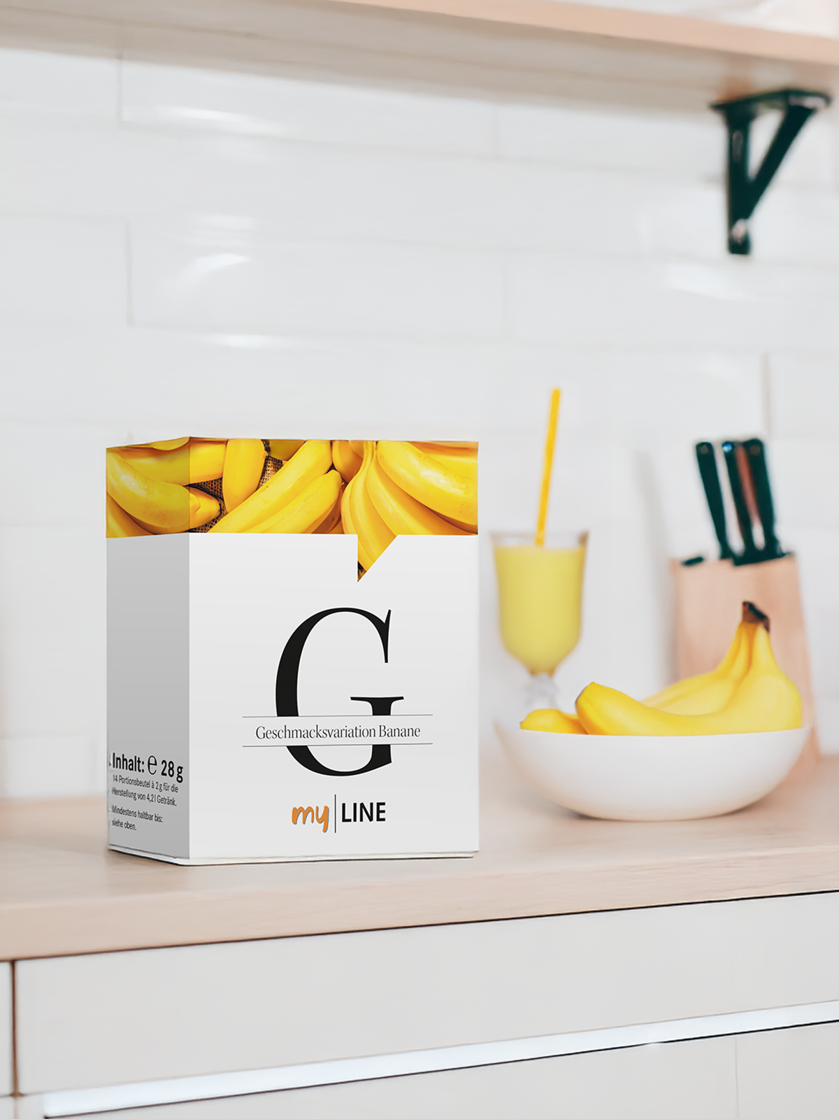 Eine Packung myLINE Geschmacksvariation Banane, Bananen und ein Shake zum Abnehmen in der Küche