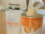 Eine Dose myLINE Basis, ein Shaker und ein Messlöffel myLINE Basis Pulver zur Zubereitung eines Abnehm-Shakes