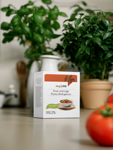 Eine Packung myLINE Fein-würzige Pasta Bolognese am Tisch
