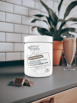 In der Küche eine Dose Shiny&Shapy Chocolate, Schokoladenstücke und ein Shake zum Abnehmen