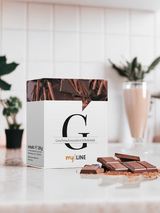 In einer Küche eine Packung myLINE Geschmacksvariation Schokolade, Schokoladenstücke und ein Schoko-Shake zum Abnehmen