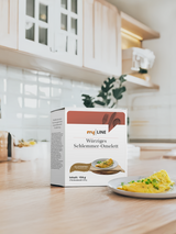 Eine Packung myLINE Würziges Schlemmer-Omelett neben einem Omelett in der Küche